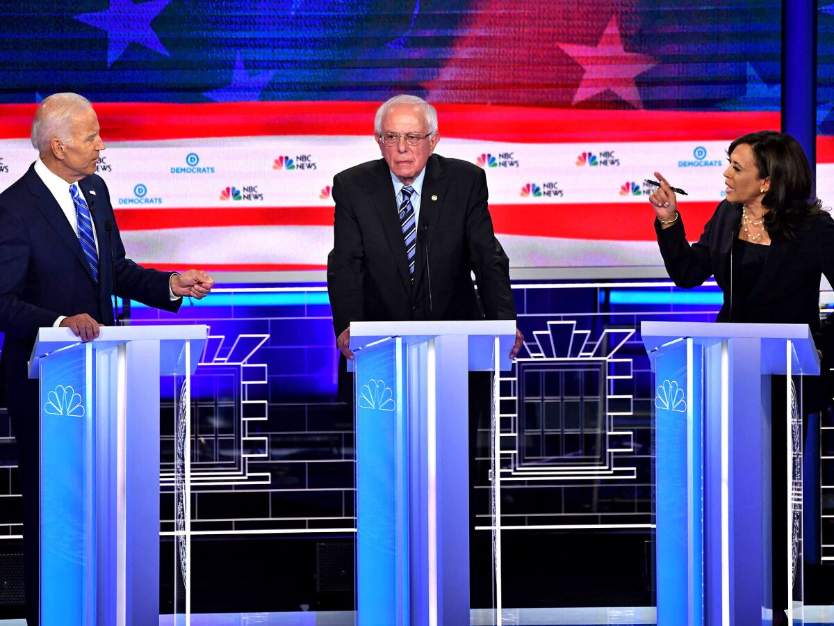 Kamala Harris makes a point to Joe Biden as Bernie Sanders looks on at a Democratic primary debate in June 2019 in Miami.
