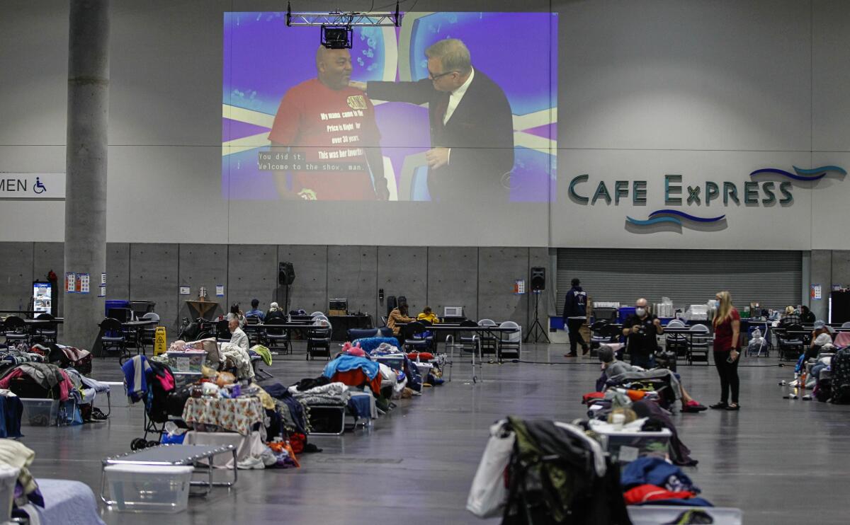 Residents watch a game show at Convention Center homeless shelter