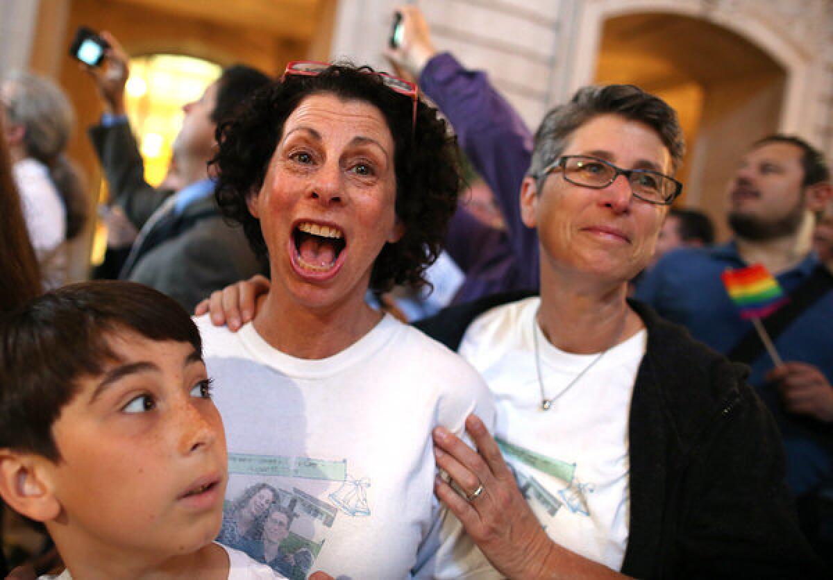 Same-sex couple Sue Rochman, center, and Robin Romdalvik, with their son Maddox Rochman-Romdalvik, celebrate in San Francisco upon hearing the U.S. Supreme Court's rulings on gay marriage.