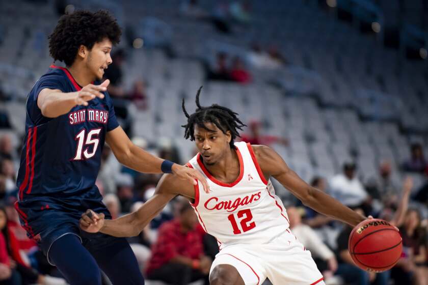 Houston guard Tramon Mark (12) drives to the basket as Saint Mary's guard Chris Howell (15) defends during the second half of an NCAA college basketball game in Fort Worth, Texas, Saturday, Dec. 3, 2022. (AP Photo/Emil Lippe)
