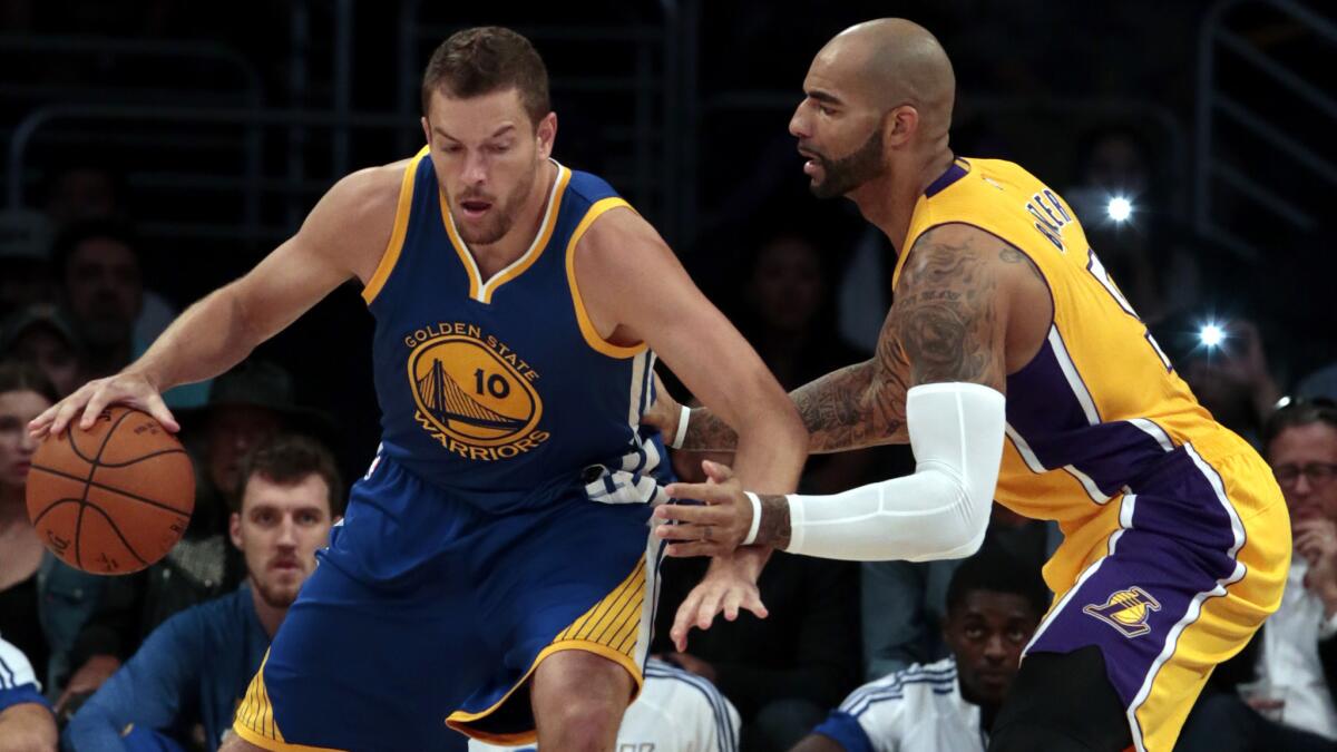 Golden State Warriors forward David Lee, left, tries to drive past Lakers forward Carlos Boozer during an exhibition game on Oct. 9.