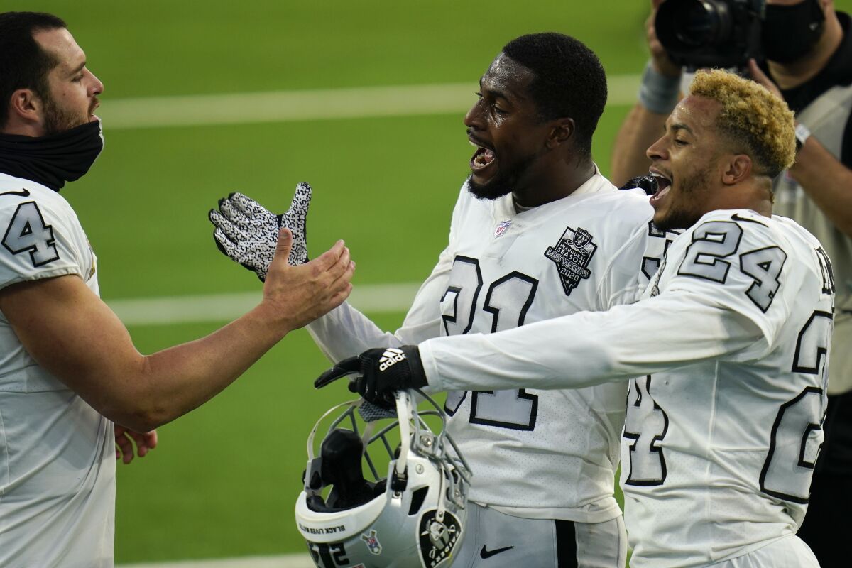 Las Vegas Raiders quarterback Derek Carr, left, celebrates with teammates cornerback Isaiah Johnson, center, and strong safety Johnathan Abram (24) after the Raiders defeated the Los Angeles Chargers in an NFL football game Sunday, Nov. 8, 2020, in Inglewood, Calif. (AP Photo/Alex Gallardo)
