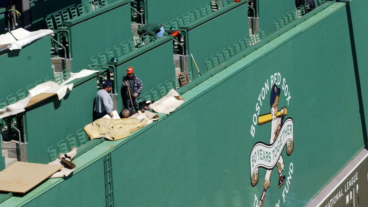 Construction workers put together the finishing touches on the new seating area atop the "Green Monster" during Fenway Park's renovation in 2003.