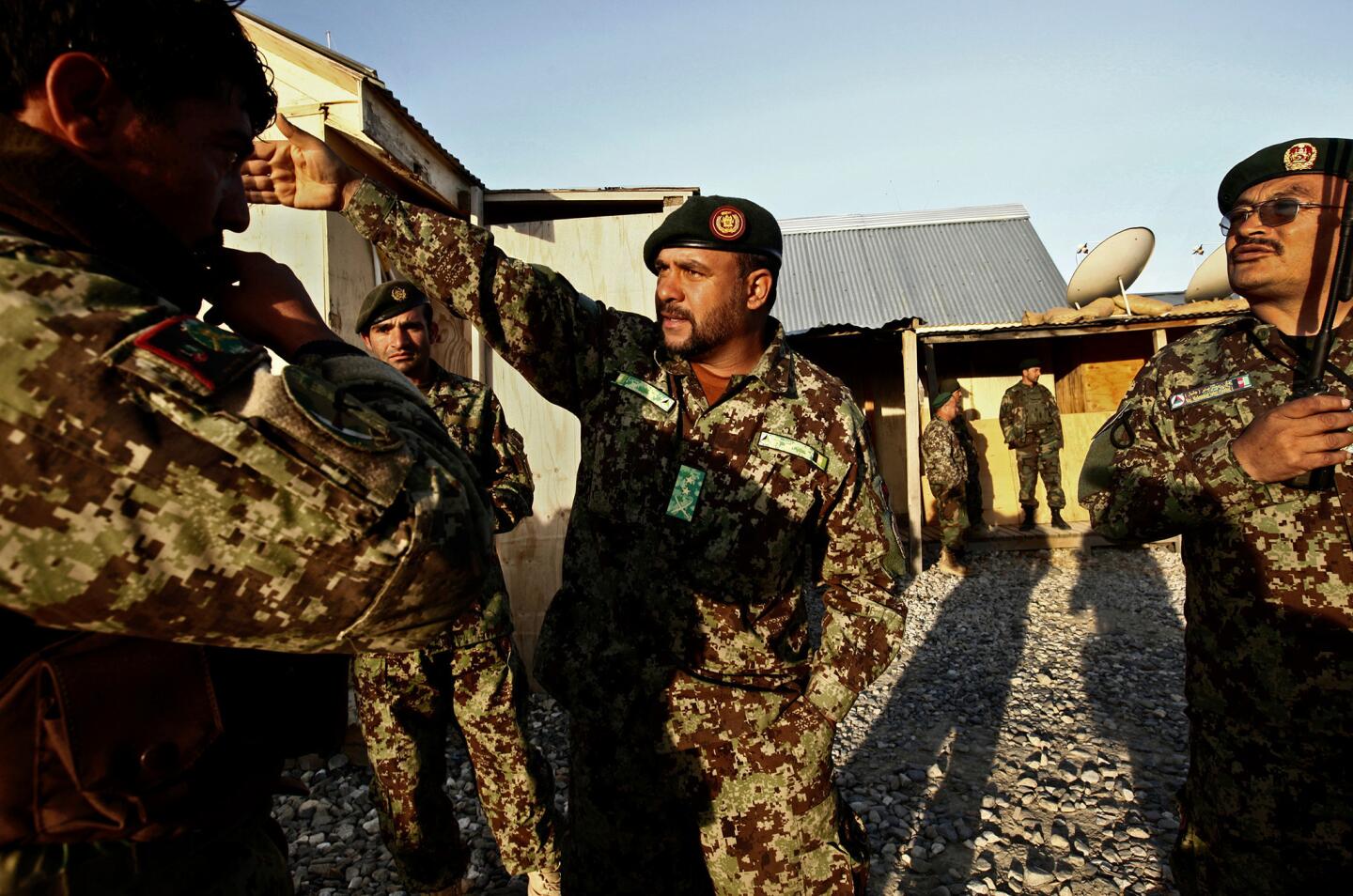 Afghan Army Lt. Col. Kohadamani Hamidullah gives orders before a mission to look for Taliban weapon supplies outside the town of Maidan Shahr.