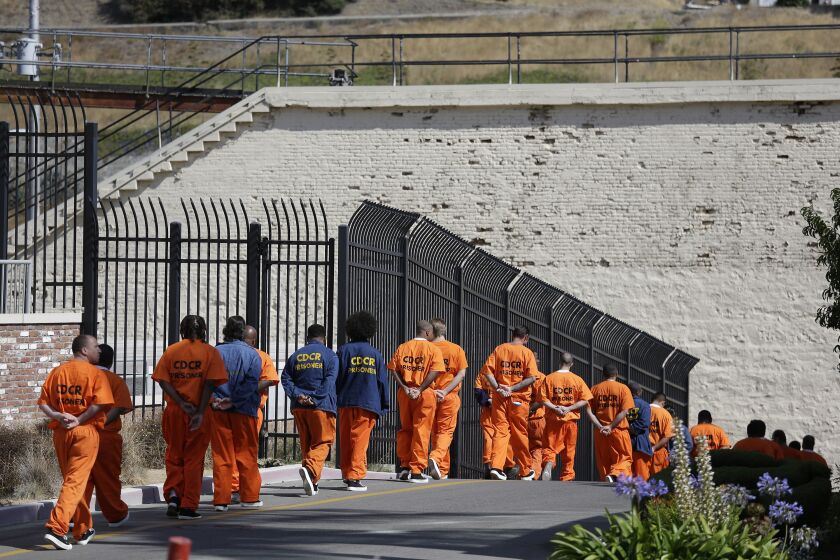 FILE - In this Aug. 16, 2016, file photo, a row of general population inmates walk in a line at San Quentin State Prison in San Quentin, Calif. California state prison officials say in a July 27, 2020, court filing that as many as 17,600 inmates are eligible for release due to the coronavirus, 70% more than previously estimated and a total that victims and police say includes dangerous criminals who should stay locked up. (AP Photo/Eric Risberg, File)