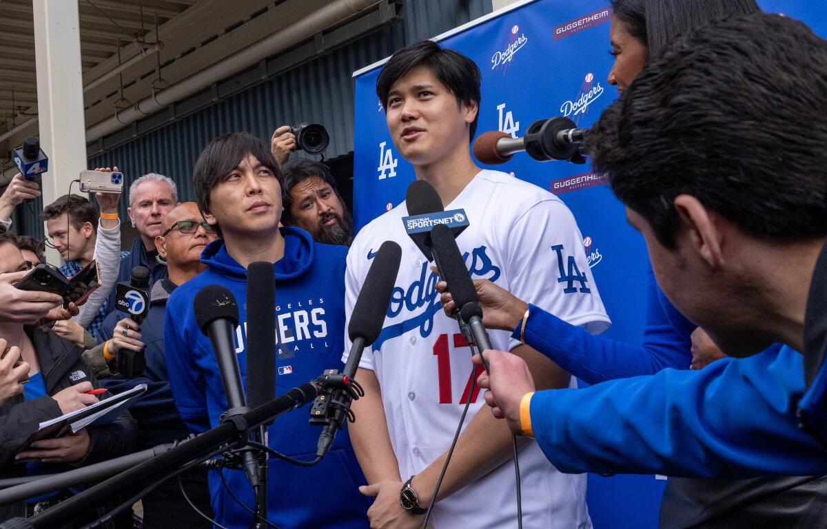 Dodgers star Shohei Ohtani speaks to reporters with his interpreter at his side