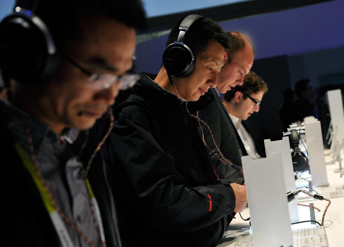 Attendees listen to music with Sony's MDR-1A headphones at the 2015 International CES at the Las Vegas Convention Center on Tuesday in Las Vegas. How online music listening and advertising fit together were among the key discussions at CES for the entertainment industry.