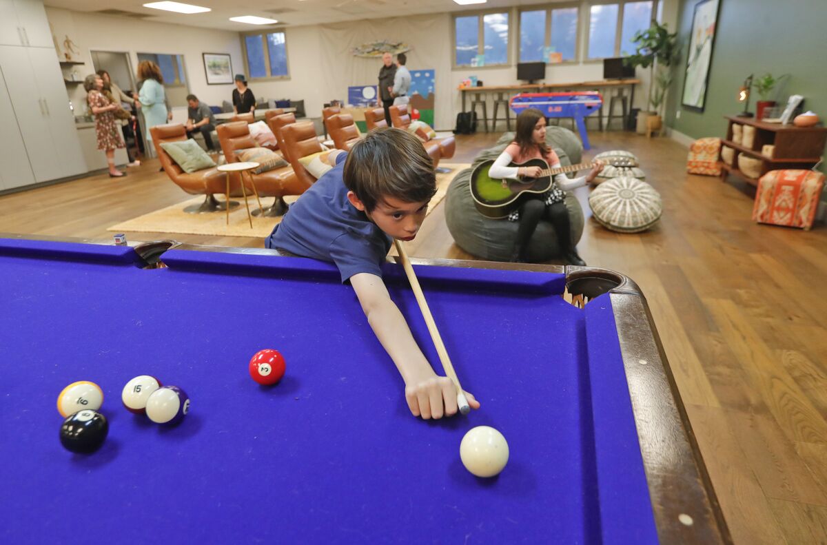 Oliver Bishop plays on the new pool table as part of the new well space room.