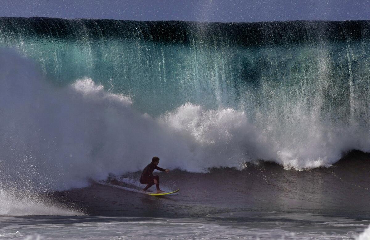 A surfer escapes a wall of water at The Wedge jetty in Newport Beach in August. Huge waves are expected in Ventura County though Saturday.