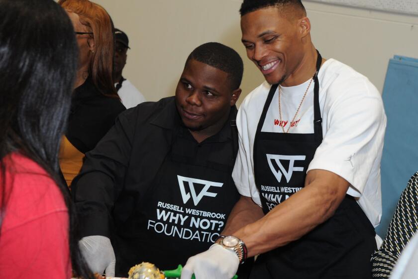 Russell Westbrook is joined by brother Raynard, left, while dishing an early Thanksgiving dinner at Jesse Owens Community Regional Park on Nov. 21, 2019. The event is part of the Russell Westbrook Why Not? Foundation.