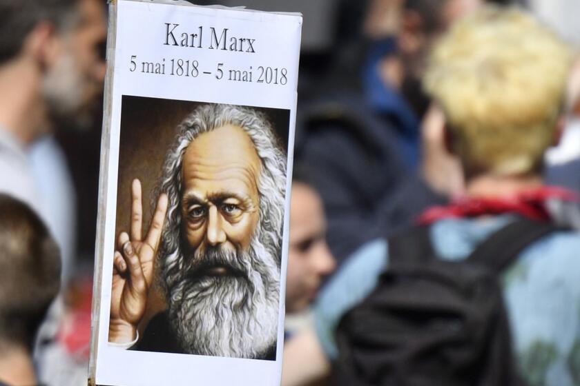A placard showing an image of Karl Marx is seen during a rally called to protest against policies of the French president on the first anniversary of his election, on May 5, 2018 in central Paris. / AFP PHOTO / GERARD JULIENGERARD JULIEN/AFP/Getty Images ** OUTS - ELSENT, FPG, CM - OUTS * NM, PH, VA if sourced by CT, LA or MoD **