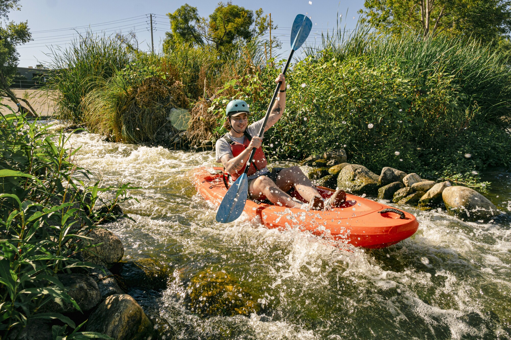 A man kayaks through the rapids on the Los Angeles River.