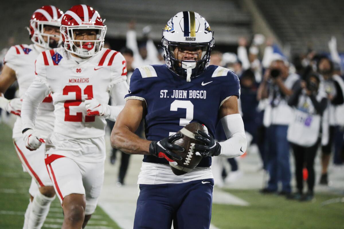 St. John Bosco wide receiver Deandre Moore runs untouched for the end zone ahead of Mater Dei defenders.