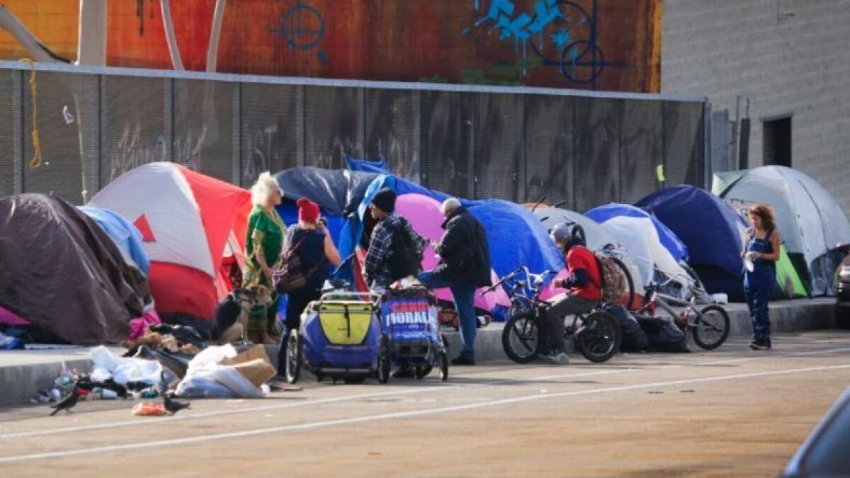 Homeless people and their tents line the Island Avenue overpass sidewalk over Interstate 5, several blocks from 14th and G Streets in the East Village.