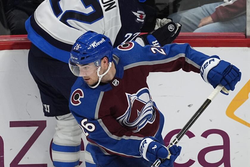 Colorado Avalanche defenseman Sean Walker (26) collects the puck after checking Winnipeg Jets center Mason Appleton (22) in the third period of Game 4 of an NHL Stanley Cup first-round playoff series Sunday, April 28, 2024, in Denver. (AP Photo/David Zalubowski)