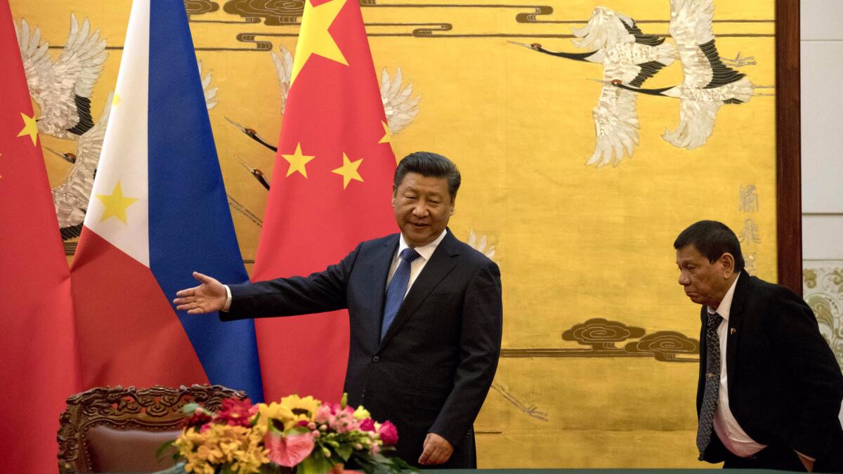 Philippine President Rodrigo Duterte, right, is shown the way by Chinese President Xi Jinping before a signing ceremony in Beijing.