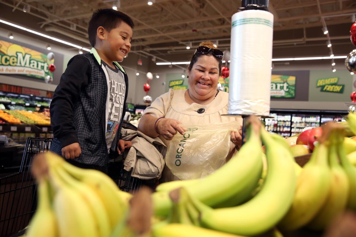 A boy and his grandmother shop at a supermarket. 