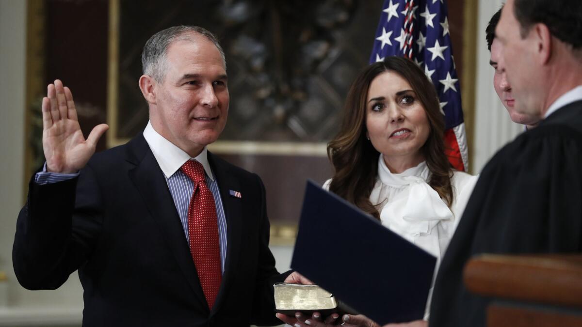 Supreme Court Justice Samuel Alito swears in Scott Pruitt as the Environmental Protection Agency administrator in February 2017, as his wife, Marlyn Pruitt, watches.
