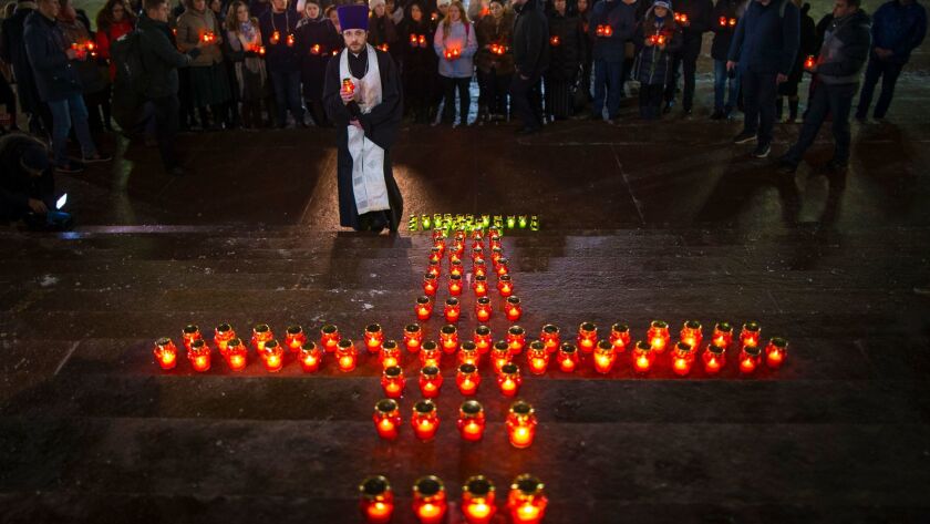 Orthodox youth with a priest gather at the Cathedral of Christ the Savior in Moscow on Feb. 12, 2018, lighting 71 candles in memory of those killed in Sunday's An-148 plane crash.