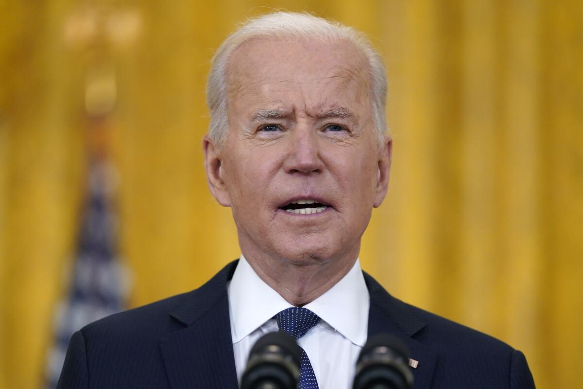 President Biden speaks at a microphone.