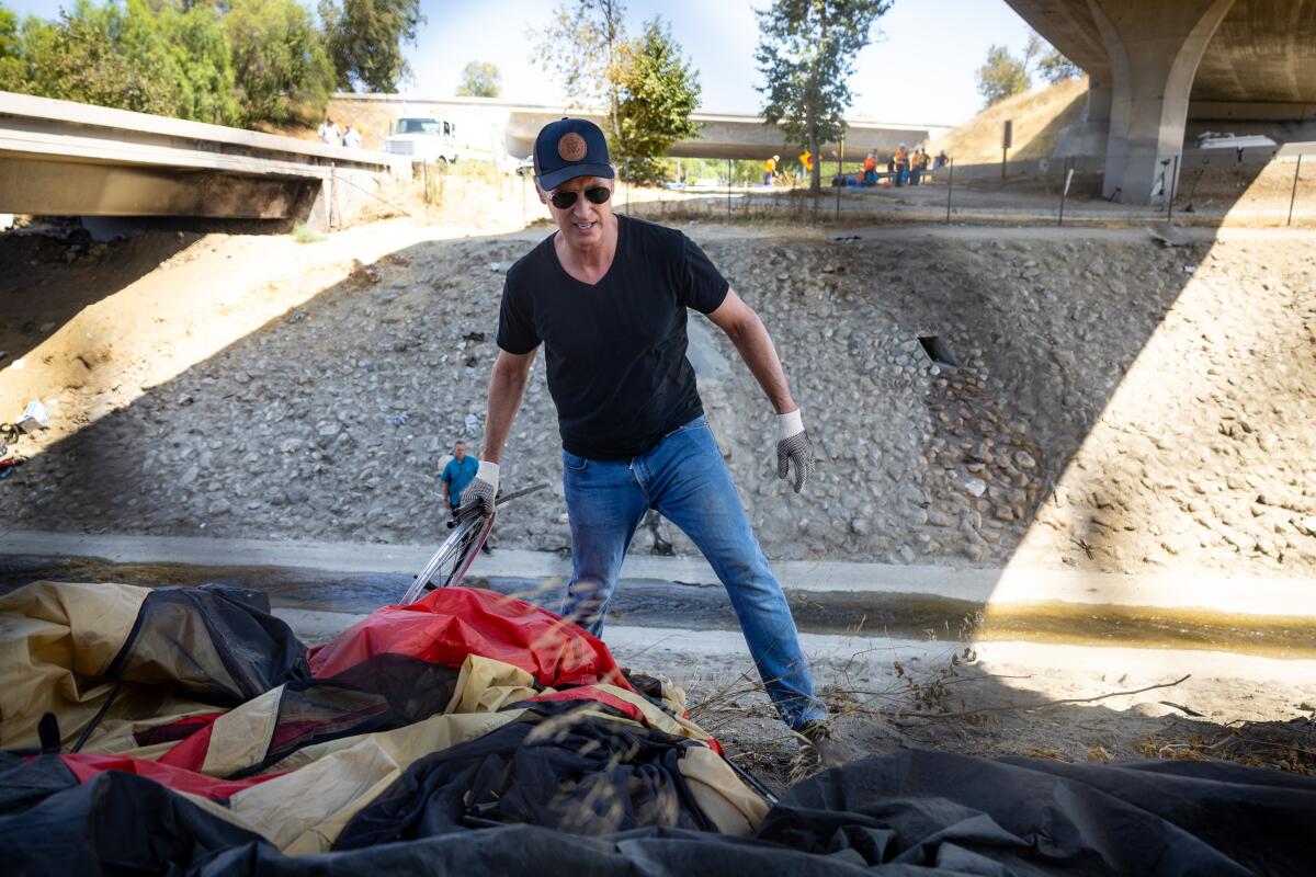 Gov. Gavin Newsom assists with a homeless encampment cleanup in Los Angeles on Aug. 8. 