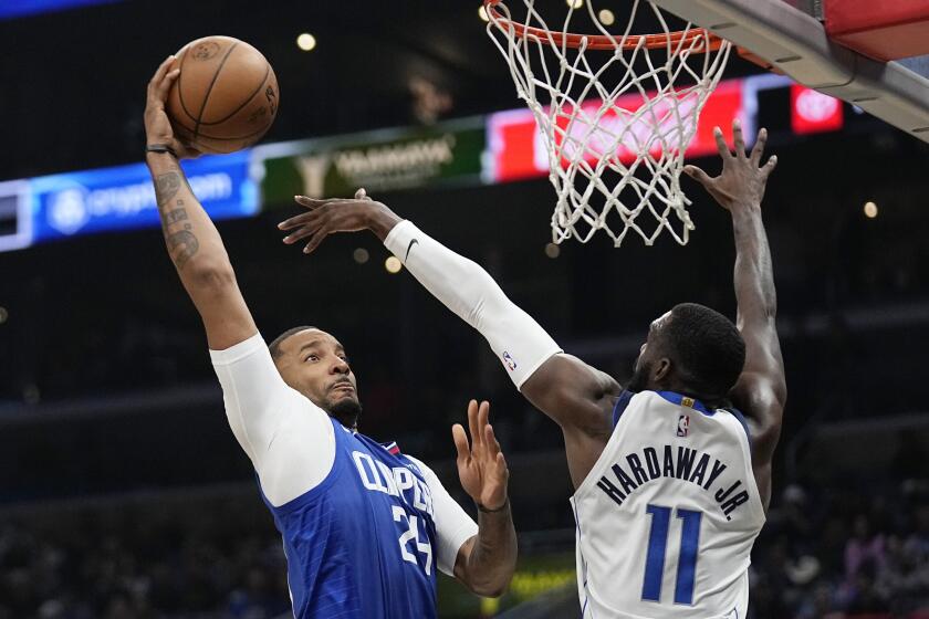 Los Angeles Clippers forward Norman Powell, left, dunks over Dallas Mavericks forward Tim Hardaway Jr. during the second half of an NBA basketball game Tuesday, Jan. 10, 2023, in Los Angeles. (AP Photo/Mark J. Terrill)