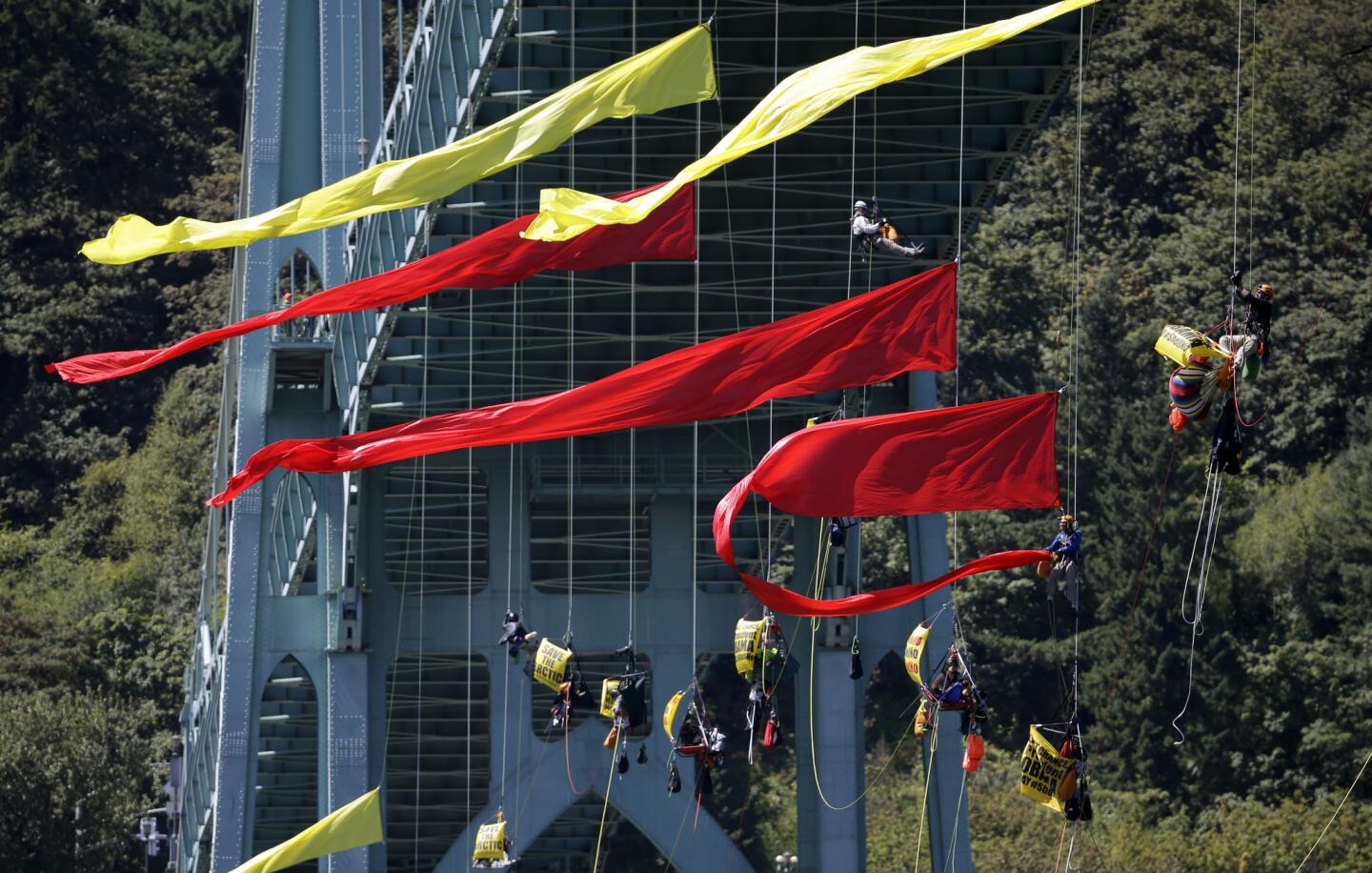 Activists unfurl colored banners while hanging from the St. Johns bridge in Portland, Ore., on July 29.