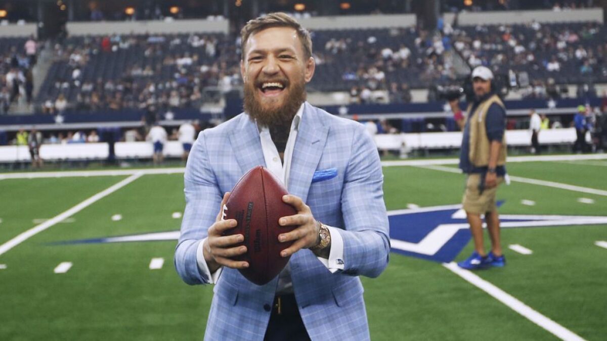 Conor McGregor hangs out on the Dallas Cowboys' sideline before a game against Jacksonville on Oct. 14 in Arlington, Texas.