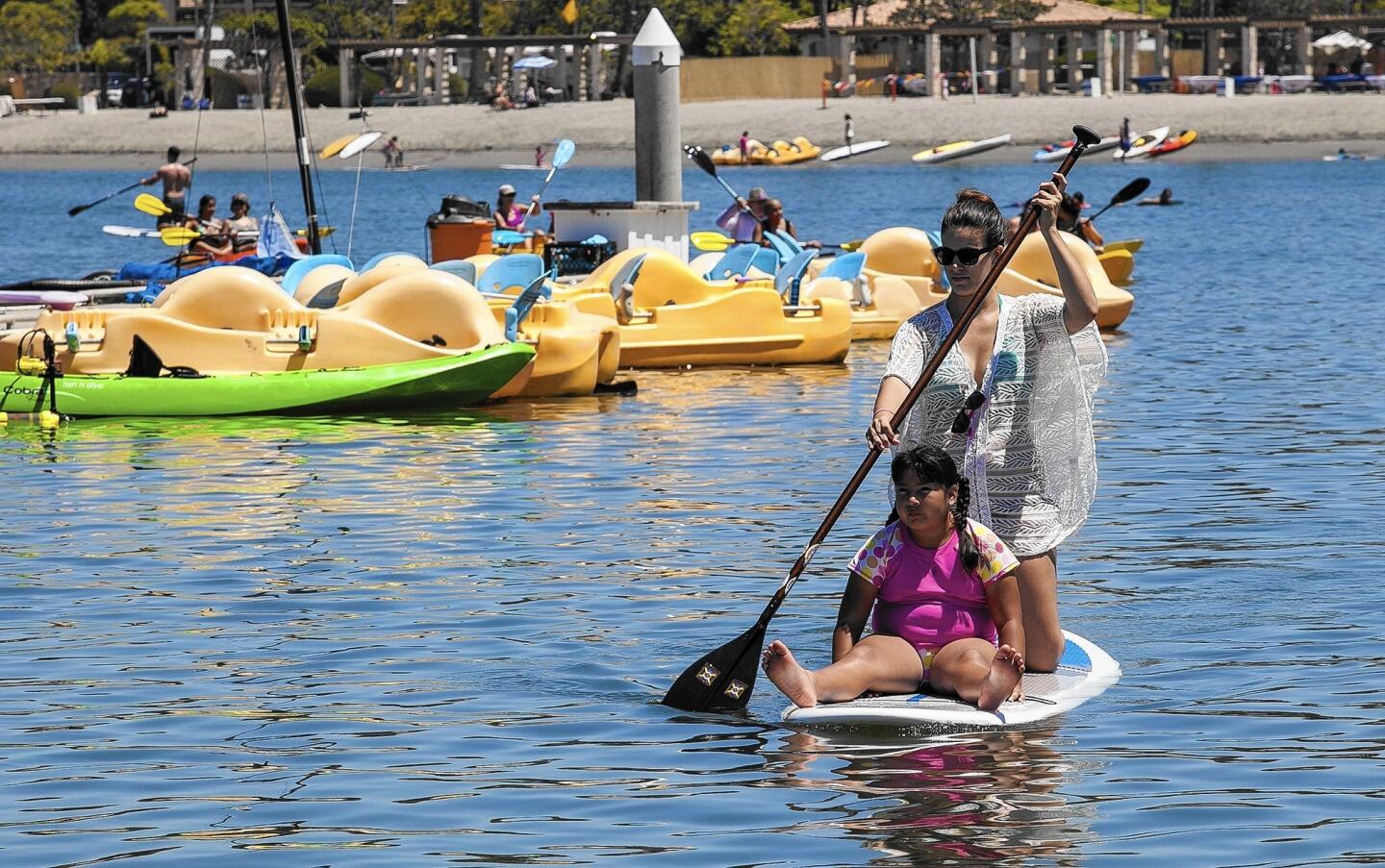 Kathryn Zarkos and Vanessa, 8, ride a paddleboard during the Big F.U.N. Kayak Day for members of Big Brothers Big Sisters of Orange County on Saturday at Newport Dunes in Newport Beach.