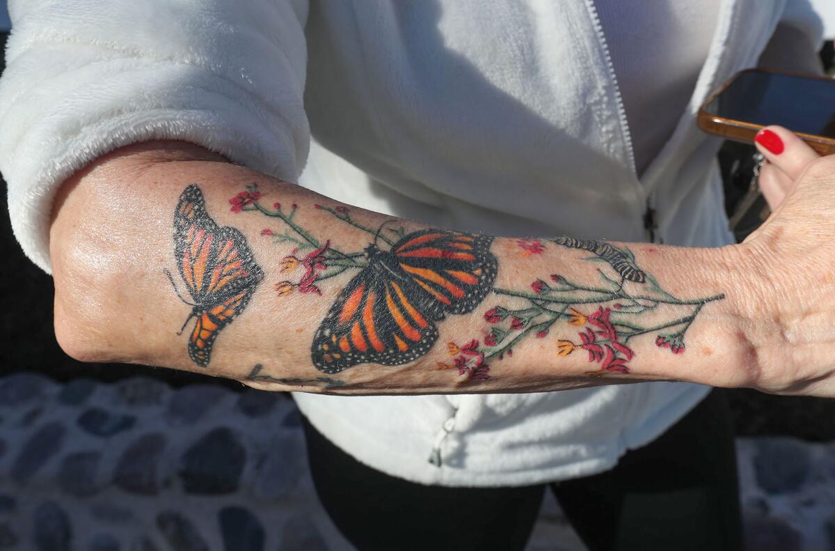 Butterfly lover Kim Pickard shows her monarch tattoo at Costa Mesa's Mariposa Garden.