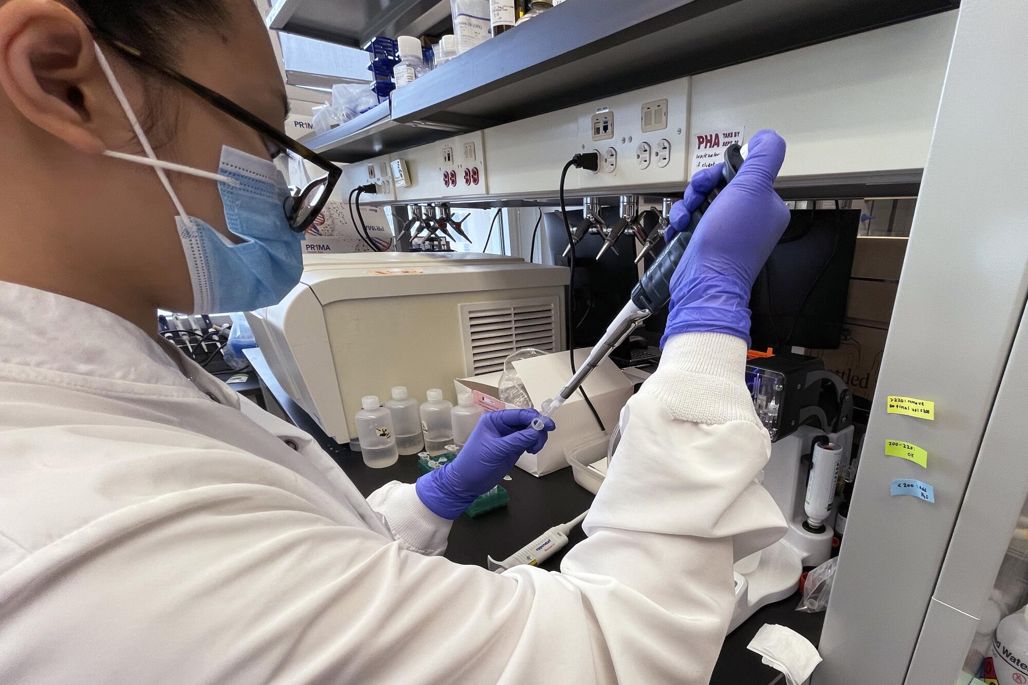 A researcher in a lab tests samples of water. 