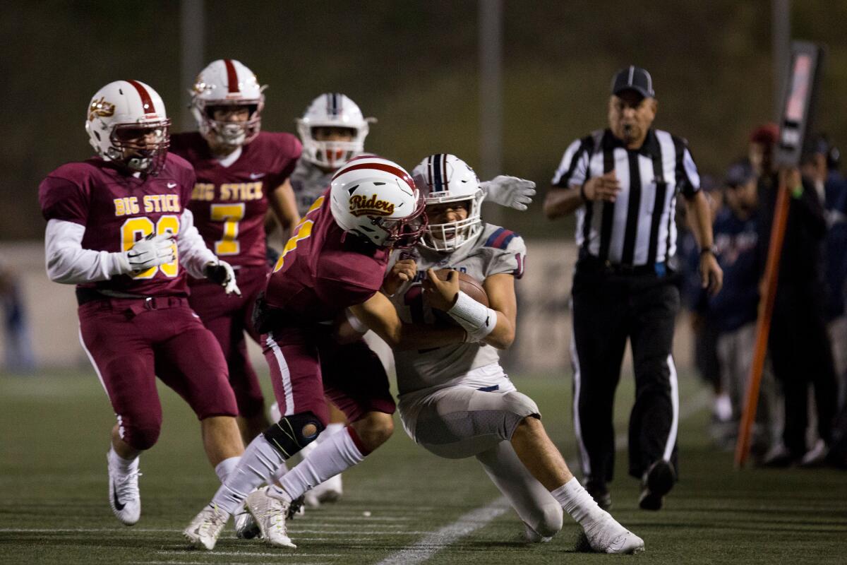 Garfield quarterback Jonathan Bautista is pushed out of bounds against Roosevelt in the East L.A. Classic on Friday night.