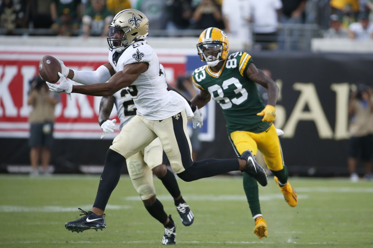 New Orleans Saints free safety Marcus Williams, left, intercepts a pass in front of Green Bay Packers wide receiver Marquez Valdes-Scantling (83) during the second half of an NFL football game, Sunday, Sept. 12, 2021, in Jacksonville, Fla. (AP Photo/Stephen B. Morton)