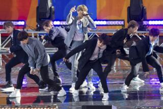A group of men in suits singing and dancing on a stage