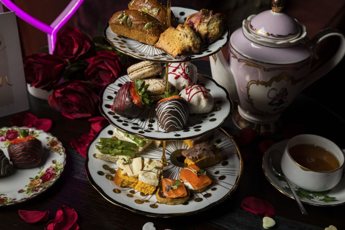 A tea tower with chef-curated pastries, a tea pot and cup of tea at Lovers' Lane High Tea & Highballs at Lilly Rose.