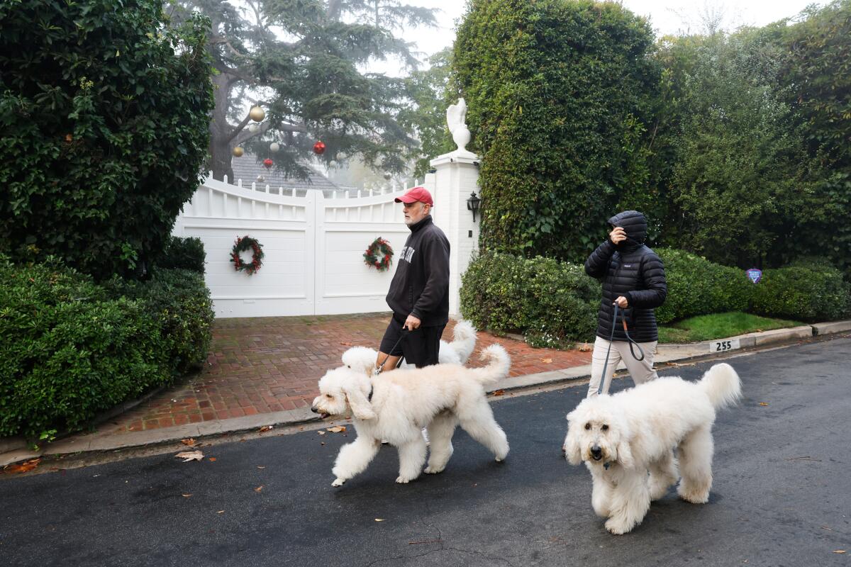 People walking dogs past Rob Reiner's residence