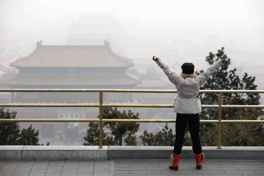A woman visits the Forbidden City in Beijing. "The air pollution is unprecedented," said Zhao Zhangyuan of the Chinese Research Academy of Environmental Sciences.