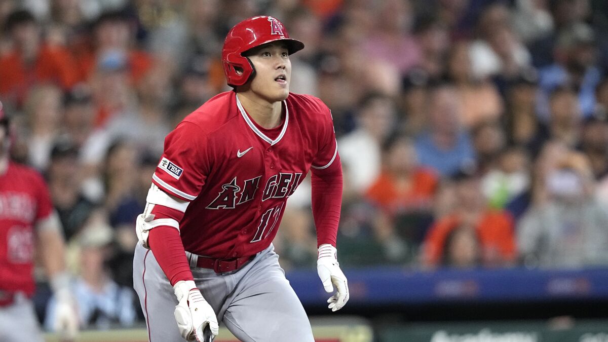 Shohei Ohtani leans forward, starts to drops his bat and watches his double against the Houston Astros 