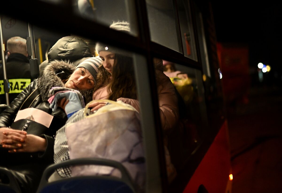 A mother and her child wait on a bus at the border in Medyka, Poland.