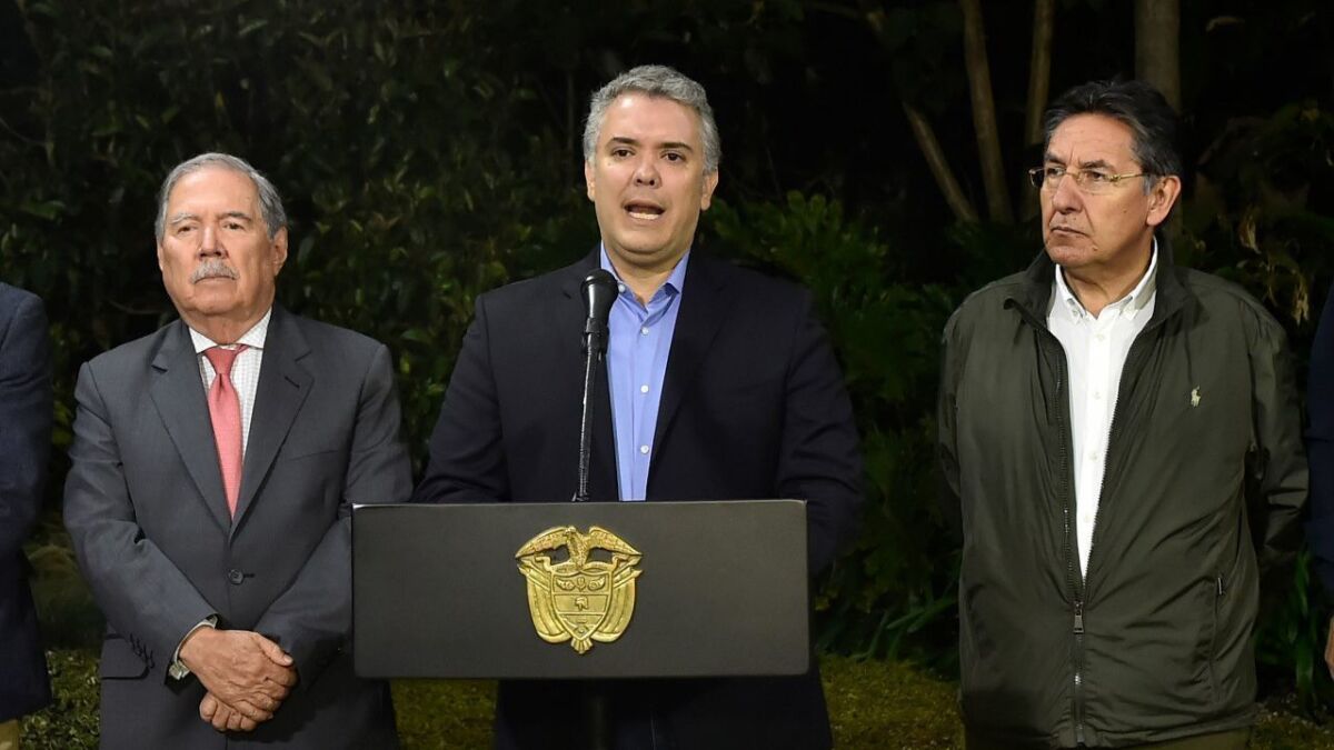 Colombian President Ivan Duque, center, speaks in Bogota on Dec. 21, about the death of Walter Patricio Arizala, aka "El Guacho." Next to Duque are Defense Minister Guillermo Botero, left, and Atty. Gen. Nestor Humberto Martinez.
