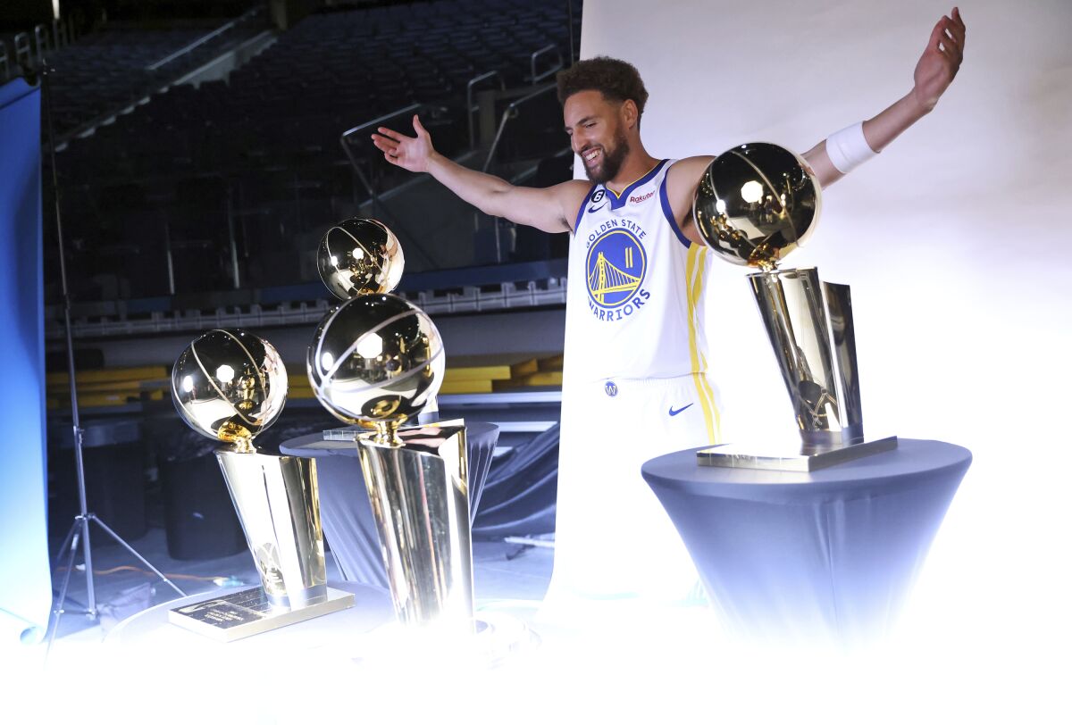 Golden State Warriors' Klay Thompson poses with four Larry O'Brien trophies during Media Day at Chase Center in San Francisco, Sunday, Sept. 25, 2022. (Scott Strazzante/San Francisco Chronicle via AP)