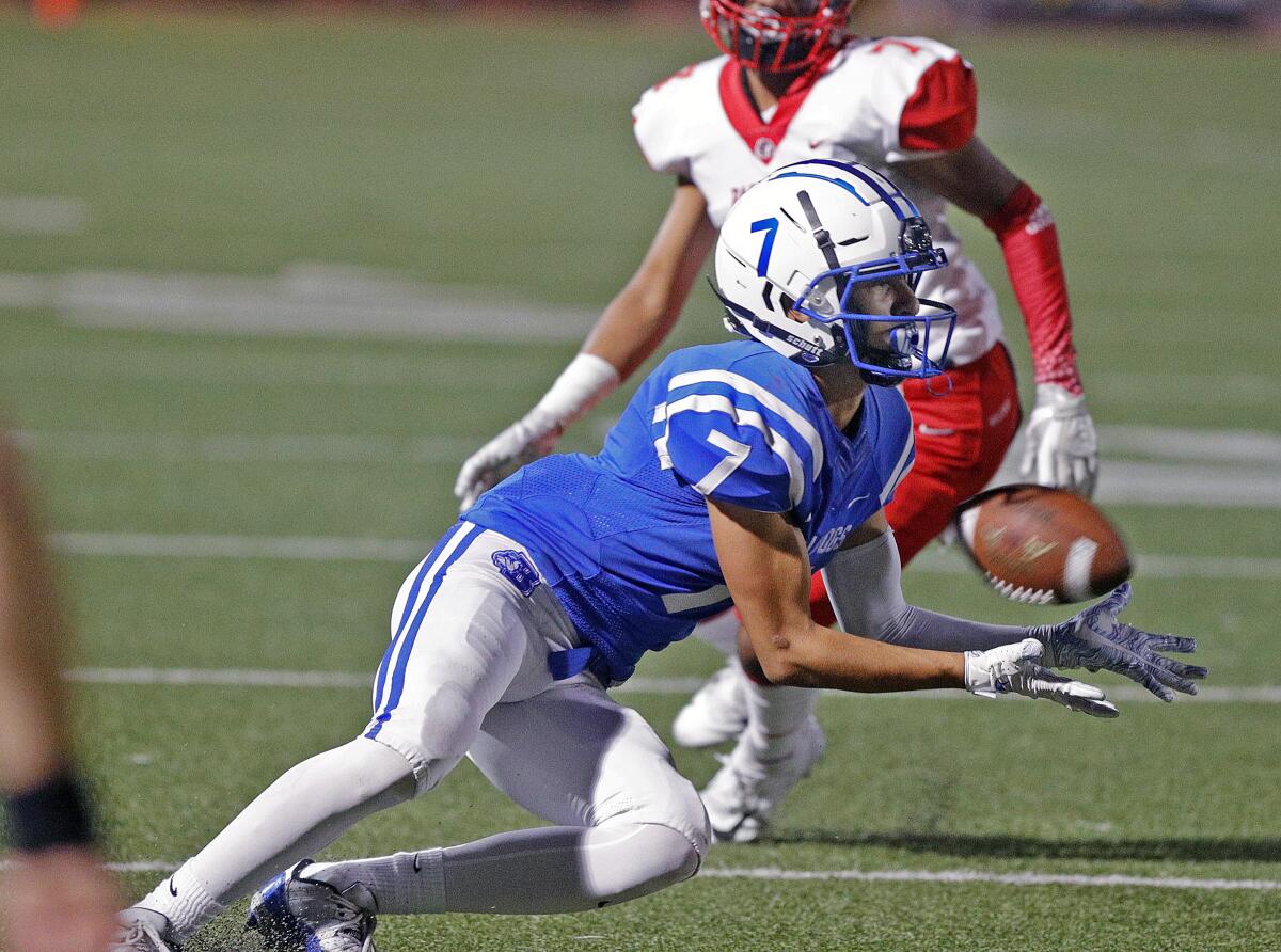 Burbank's Brandon Pena catches a pass in front of Pasadena's Troy Lisath in a Pacific League football game at Memorial Field in Burbank on Tuesday, September 26, 2019.