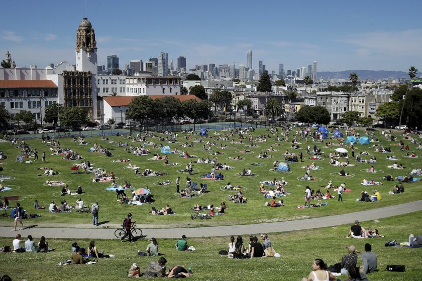 Visitors set up inside circles designed to help prevent the spread of the coronavirus at Dolores Park in San Francisco