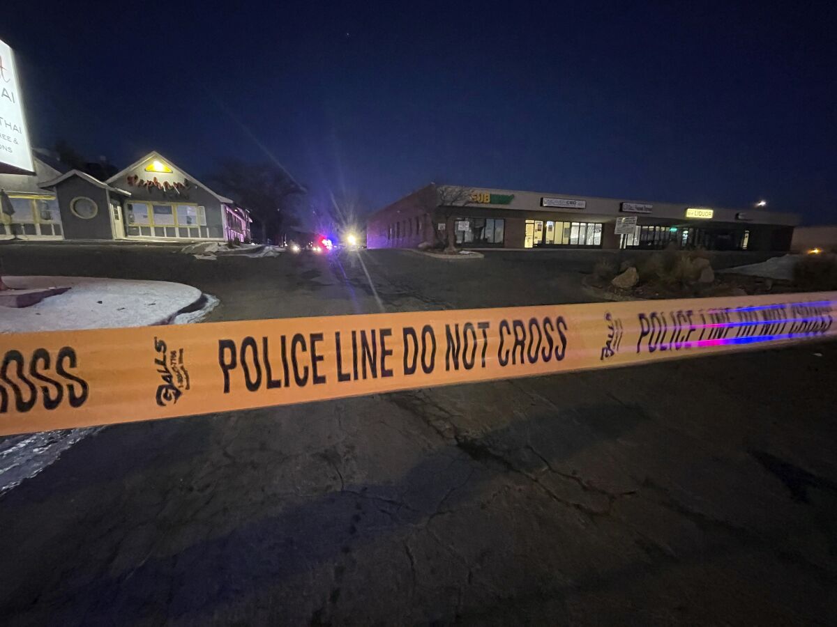 Police tape in front of a parking lot.