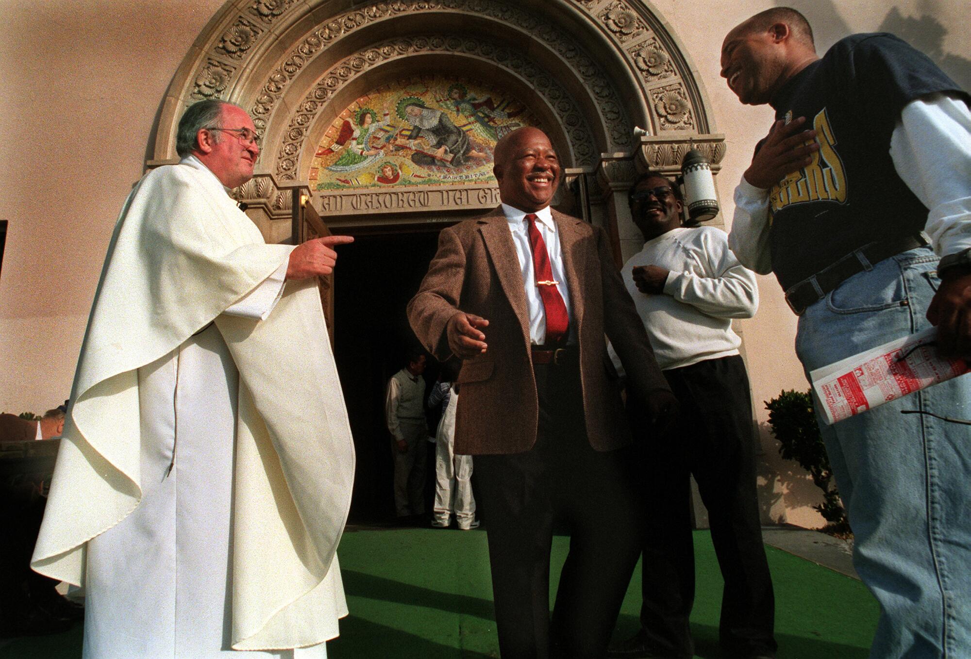 Outside a church Father Joe Carroll greets members from St. Rita's Parish