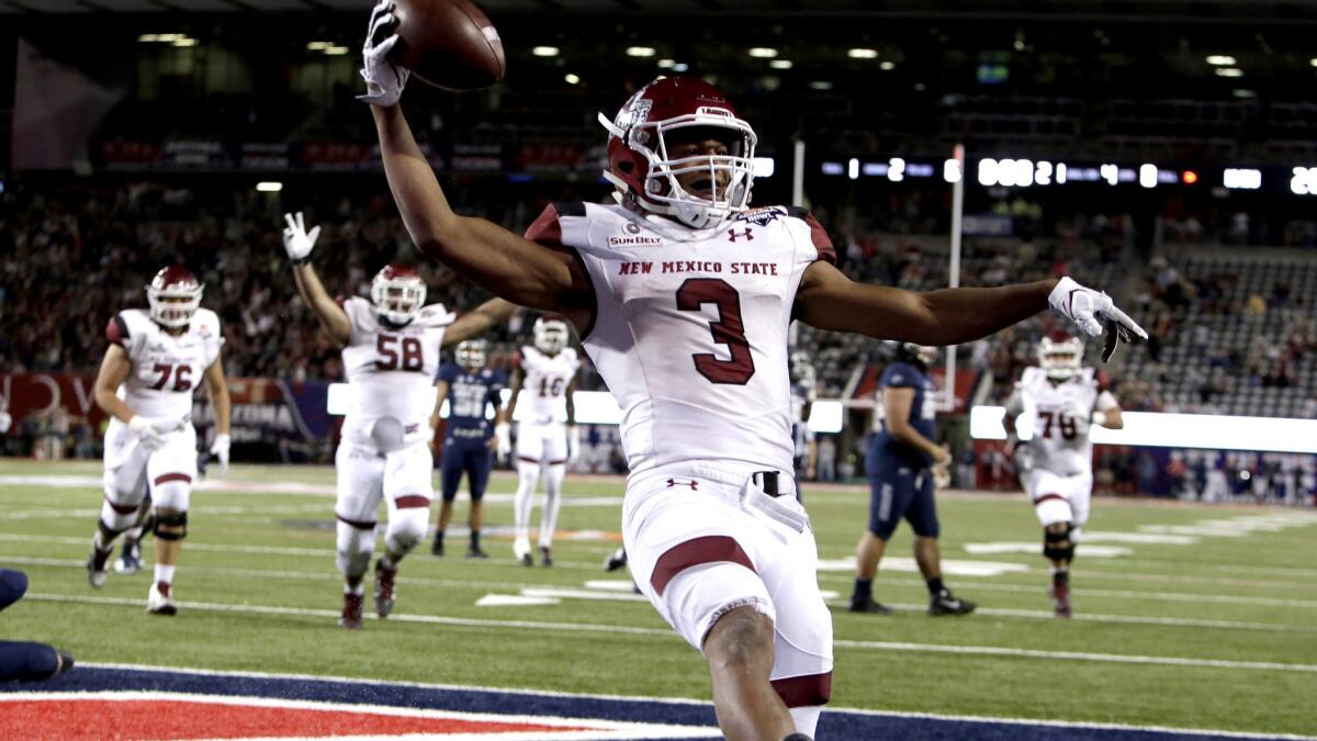 New Mexico State running back Larry Rose III celebrates after scoring a touchdown in overtime to defeat Utah State in the Arizona Bowl