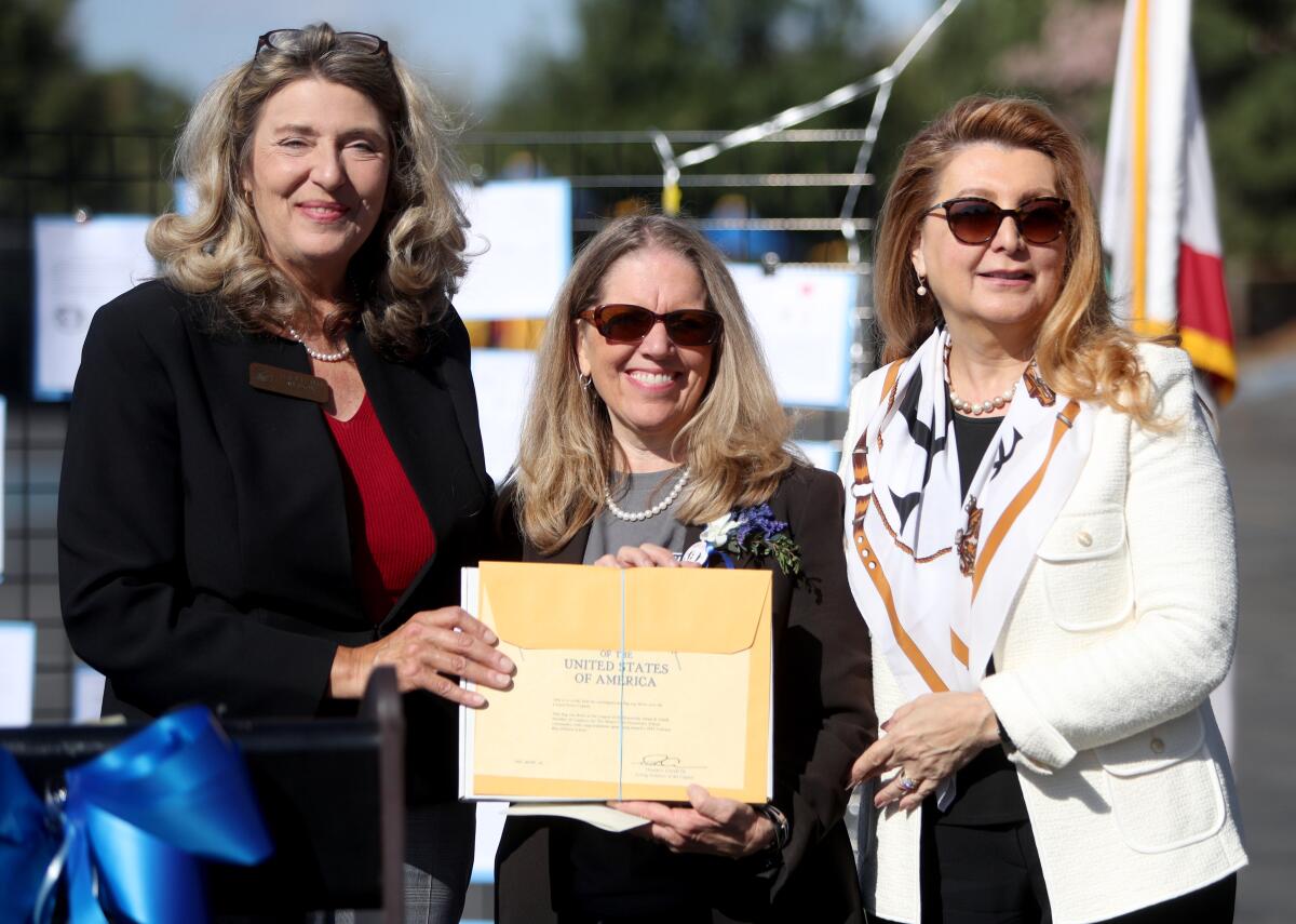 Teresa Lamb Simpson, District Representative Congressman Adam Schiff, left, presented an American flag sent by the congressman to principal Suzanne Risse, center, and superintendent Dr. Vivian Ekchian, right, during the Monte Vista Elementary School celebration for their blue ribbon award in the category of Exemplary High Performing Schools on campus in La Crescenta on Friday.