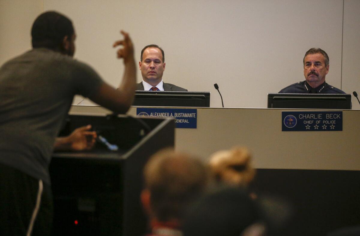 The Los Angeles Police Commission's inspector general, Alex Bustamante, and LAPD Chief Charlie Beck listen as a protester speaks at a commission meeting earlier this week. Bustamante's force report compared the LAPD to several other agencies around the country.