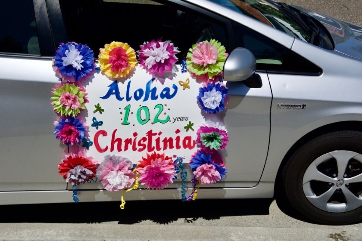 A car drives by Christinia Lee’s 102nd birthday party.