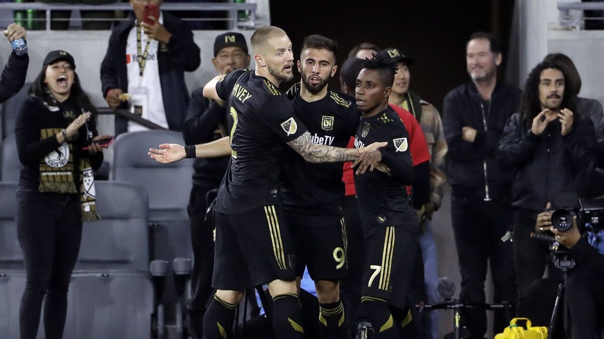 LAFC's Diego Rossi, center, is hugged by teammates Jordan Harvey, left, and Latif Blessing after Rossi's first-half goal against Real Salt Lake on Saturday.